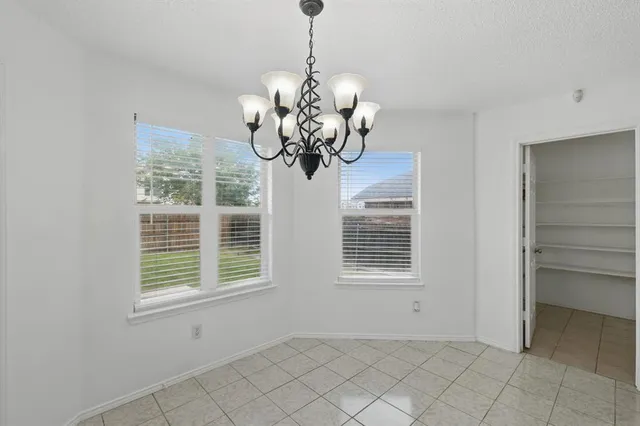 a large kitchen with granite countertop a stove top oven a sink dishwasher and white cabinets with wooden floor