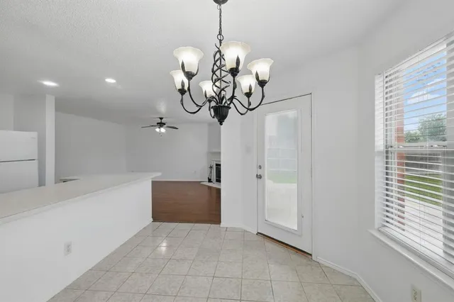 a view of a room with a chandelier furniture and windows
