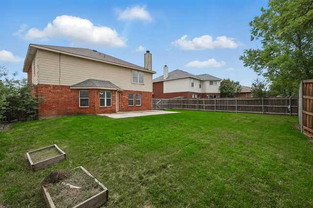 a view of a house with backyard and a tree