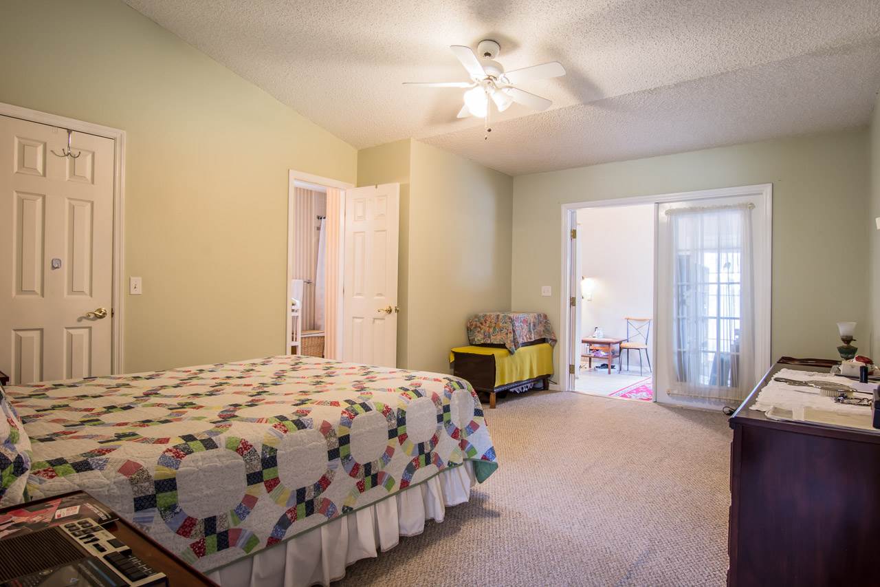 174 Segovia Road St. Augustine, FL 32086 - Photo 13 of 40 a bedroom with a bed couch chandelier and a window