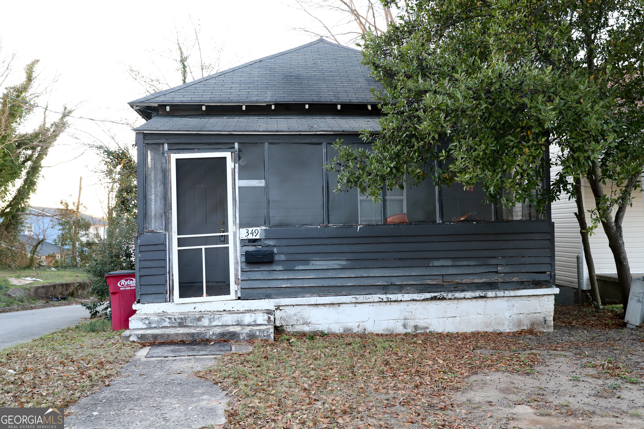 a view of a house with a yard and large tree