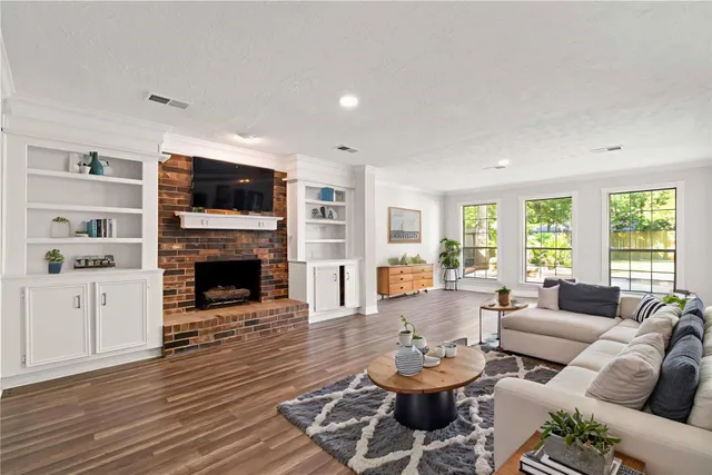 a living room with furniture a fireplace and a flat screen tv
