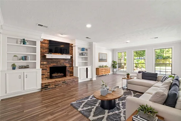 a living room with furniture and a wooden floor