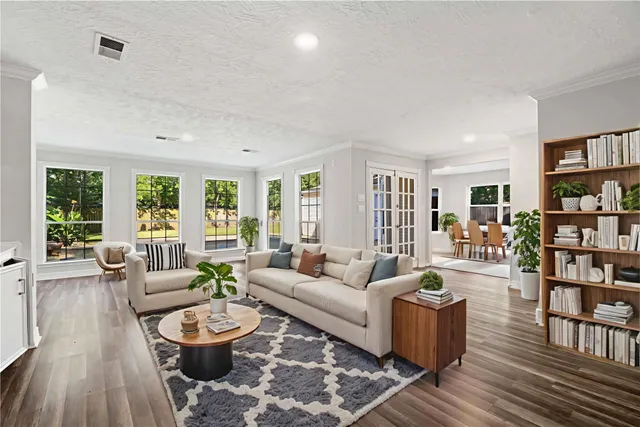 a living room with furniture and a wooden floor