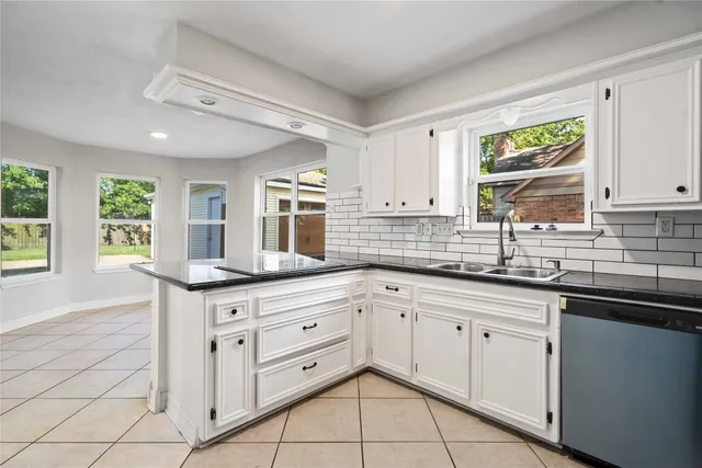 a kitchen with white cabinets and a sink