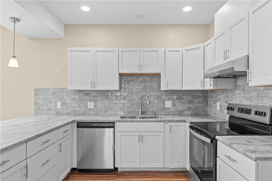1017 12th Street Corpus Christi, TX 78404 - Photo 11 of 31 a kitchen with granite countertop a sink stainless steel appliances and white cabinets