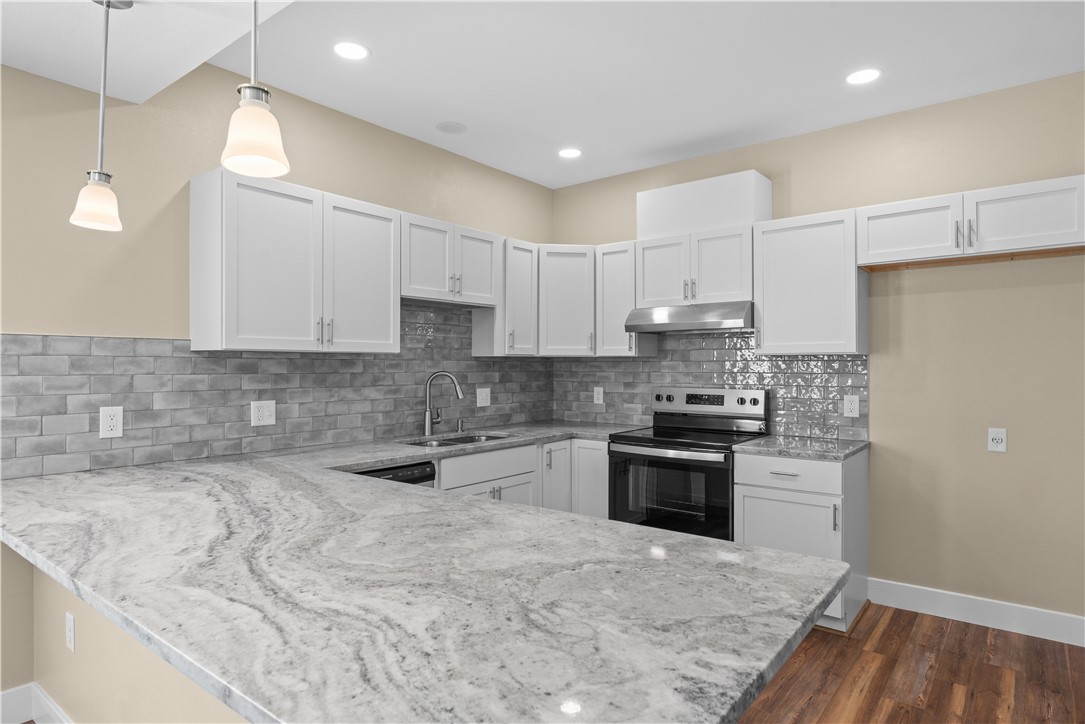 1017 12th Street Corpus Christi, TX 78404 - Photo 10 of 31 a kitchen with kitchen island granite countertop a sink stainless steel appliances and cabinets
