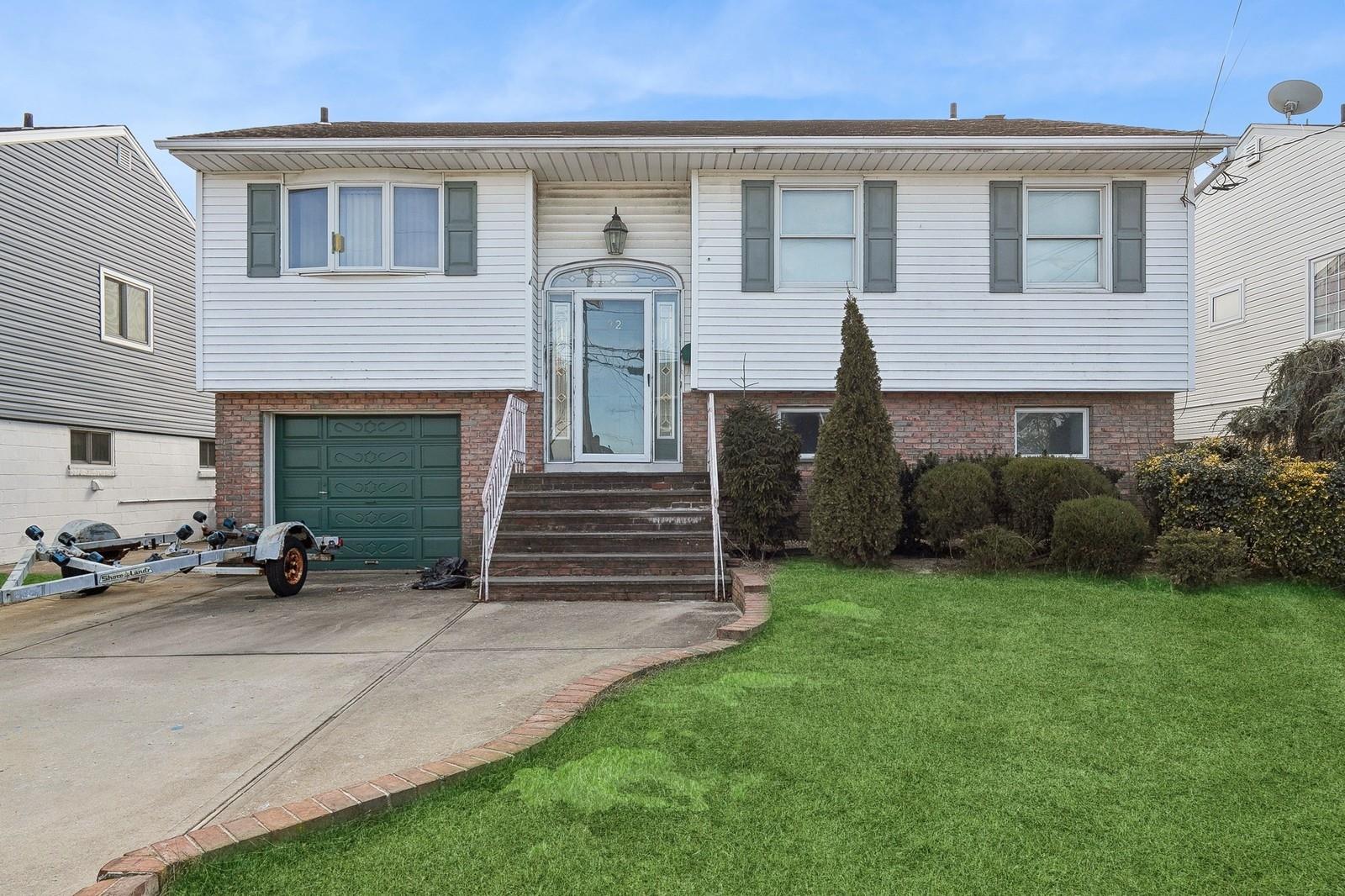 32 East 1st Street Freeport, NY 11520 - Photo 1 of 1 a view of a house with a yard and a car parked in front of it