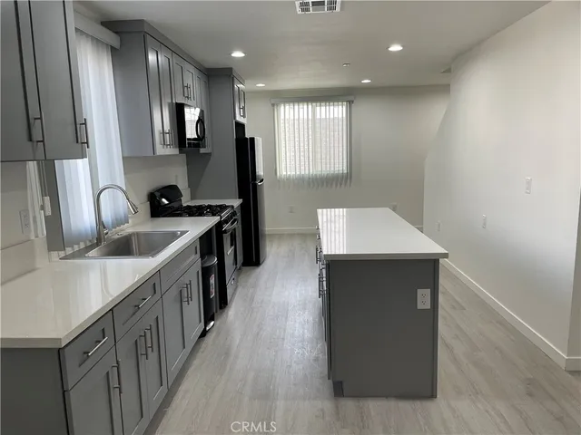 a kitchen with kitchen island sink stove refrigerator and microwave