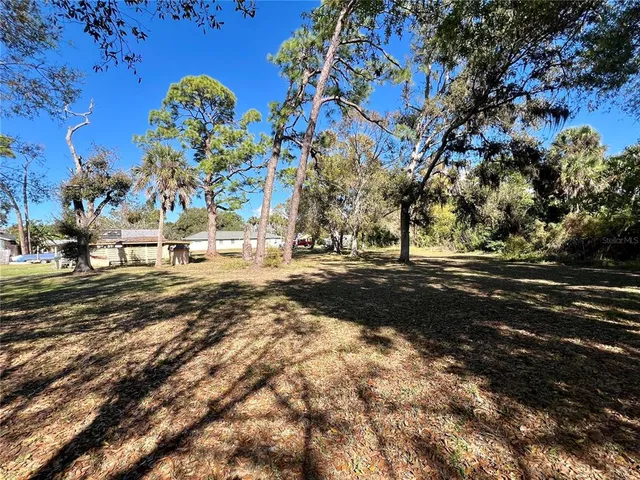 a view of street with yard and car parked
