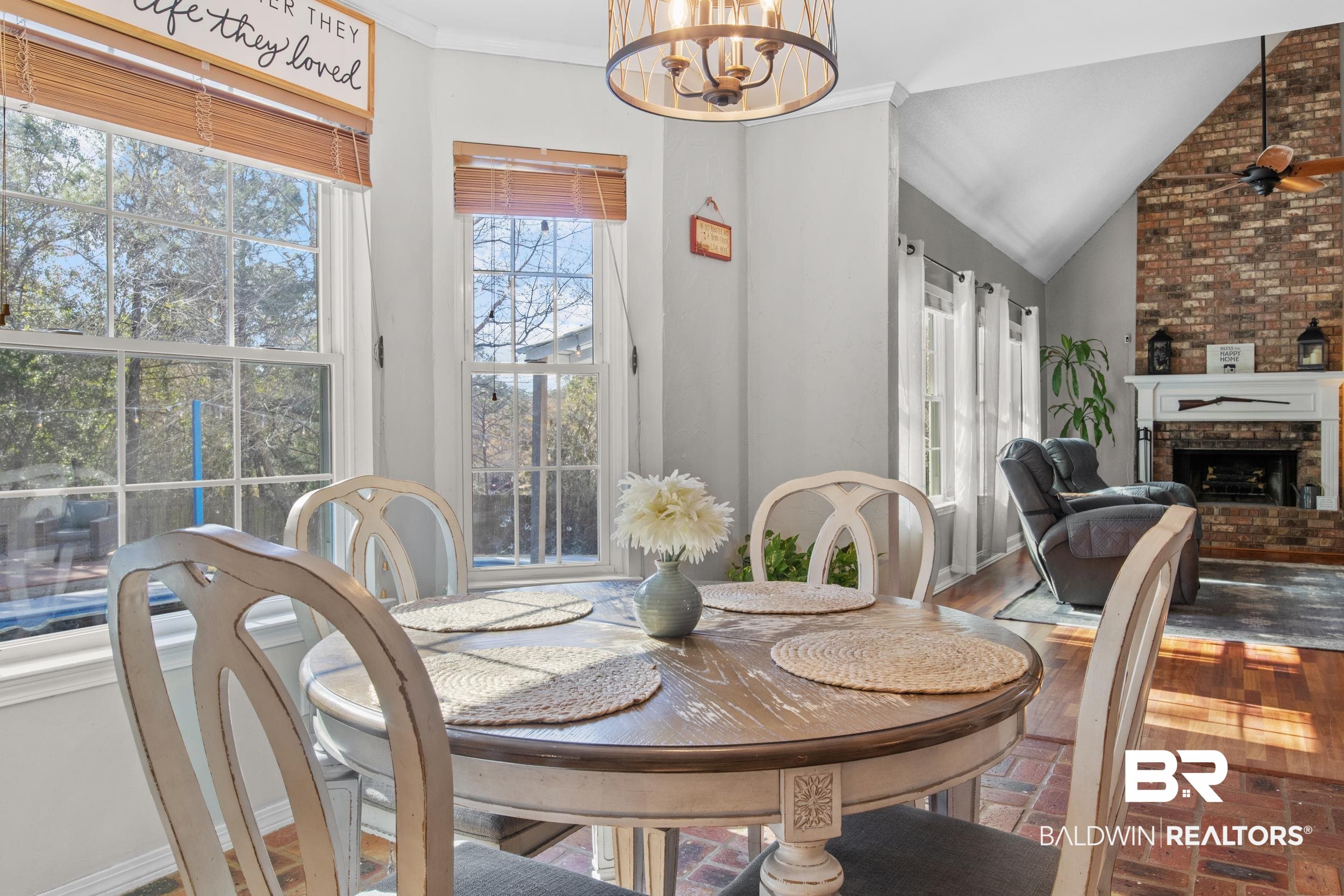 131 Marikesh Drive Daphne, AL 36526 - Photo 16 of 29 Dining area with a chandelier, vaulted ceiling, and a brick fireplace