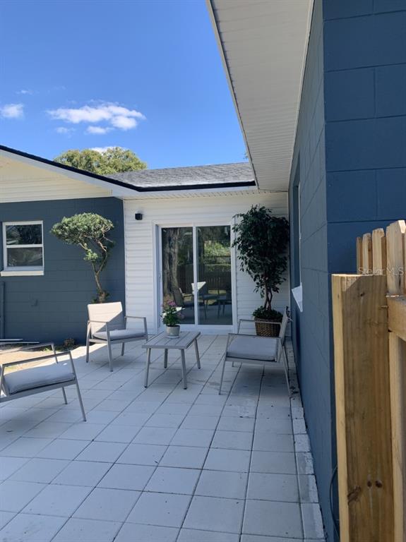 2237 Washington Road Mount Dora, FL 32757 - Photo 15 of 16 a view of a patio with couches and table and chairs with wooden floor and fence