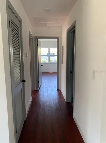 a view of a hallway with wooden floor