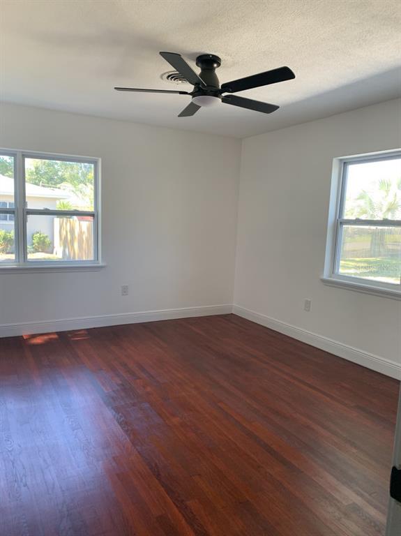 2237 Washington Road Mount Dora, FL 32757 - Photo 7 of 16 an empty room with wooden floor fan and windows