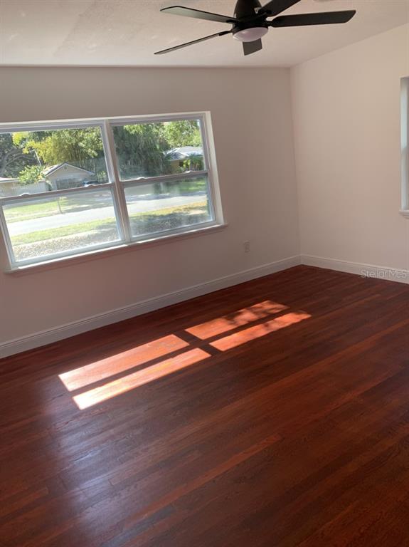 2237 Washington Road Mount Dora, FL 32757 - Photo 9 of 16 a view of an empty room with wooden floor and a window