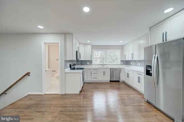 a kitchen with white cabinets and white appliances