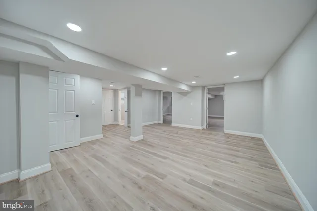 a view of an empty room with wooden floor and closet