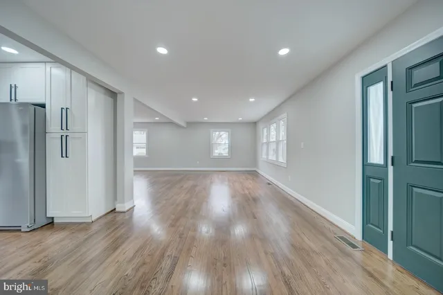 a view of empty room with wooden floor and window