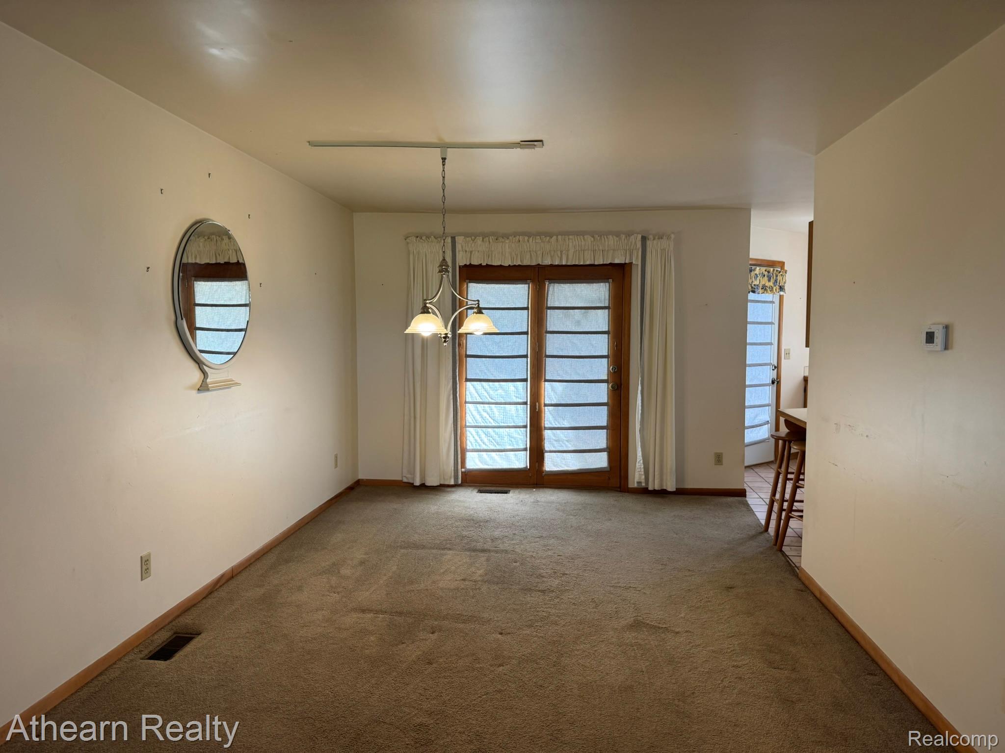 11449 Torrey Road Fenton, MI 48430 - Photo 11 of 30 Recessed lighting fixture, brown carpet, white wall paint, wood-framed glass sliding door, and a hanging chandelier