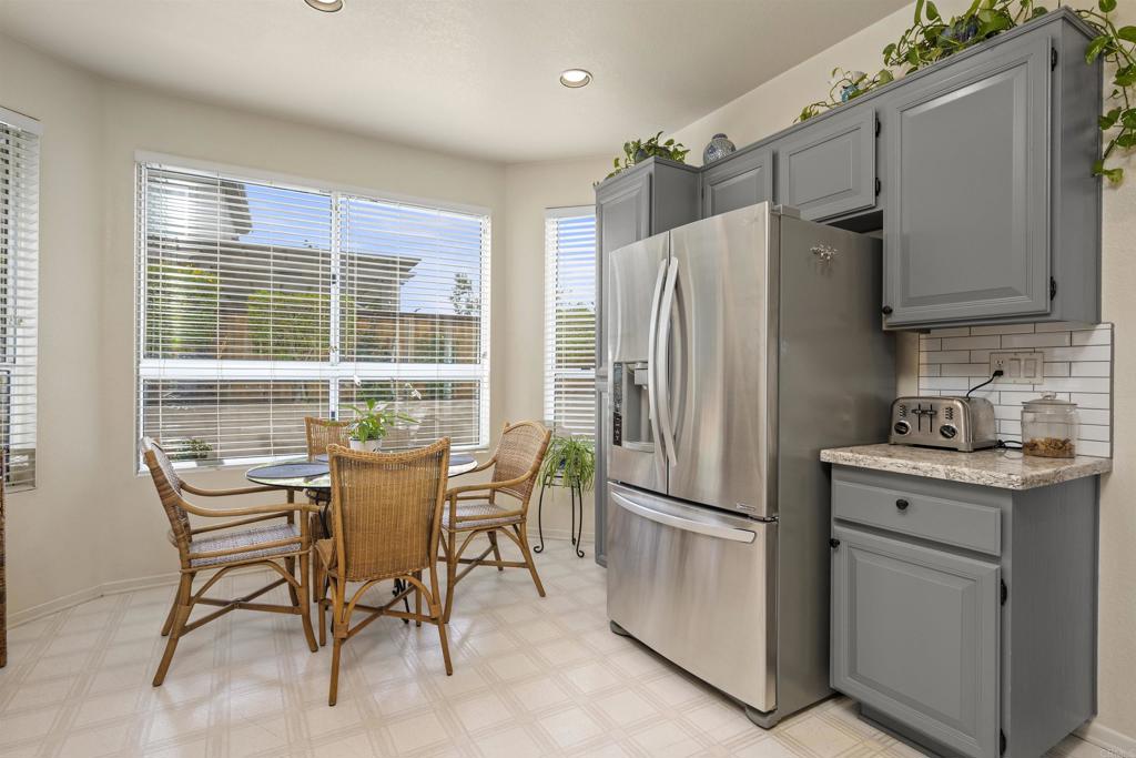 a kitchen with stainless steel appliances a refrigerator a stove a dining table and chairs