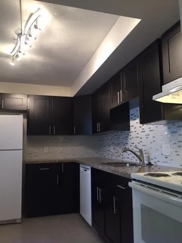 a kitchen with stainless steel appliances granite countertop a sink a stove and a refrigerator