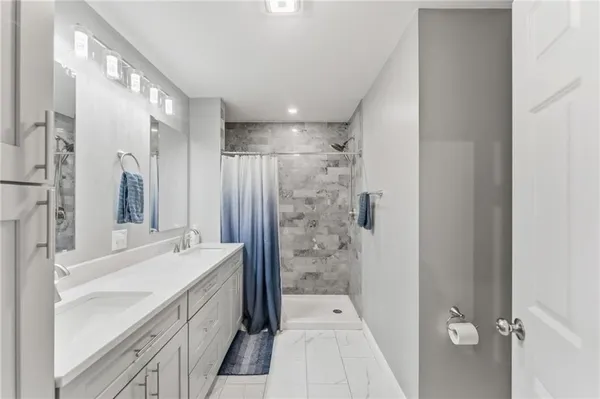 a bathroom with a double vanity sink mirror double and shower