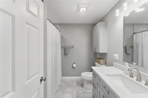 a bathroom with a sink a toilet a tub and shower