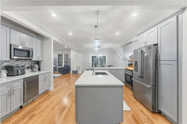 a kitchen with granite countertop stainless steel appliances cabinets a sink and a counter top space