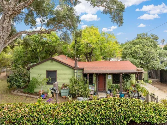 a view of a house with table and chairs under an umbrella