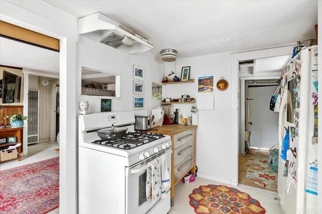 a kitchen with stainless steel appliances granite countertop a refrigerator and a stove top oven