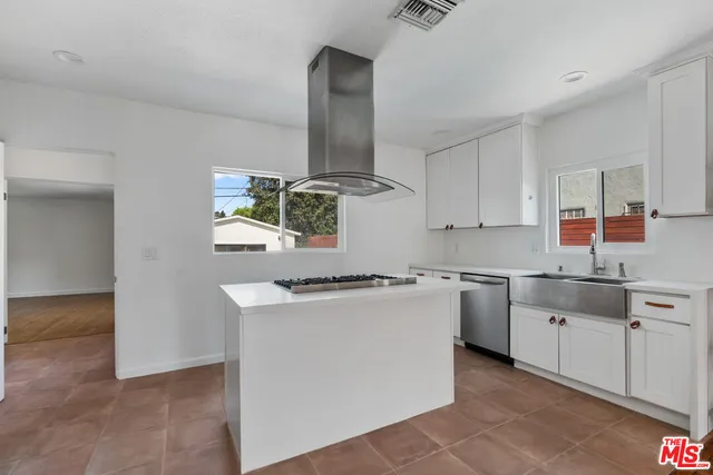 a kitchen with wooden cabinets a sink a stove and a window