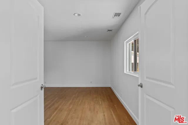 a view of an empty room with wooden floor