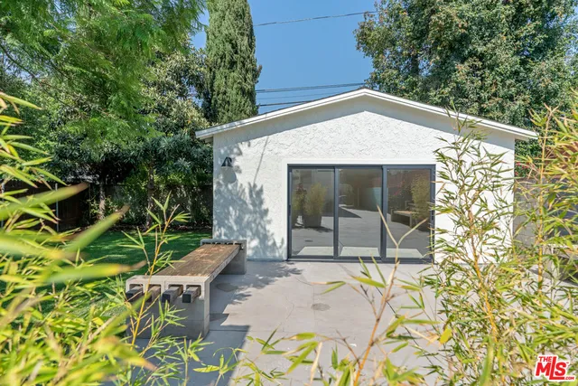 a patio with table and chairs and potted plants