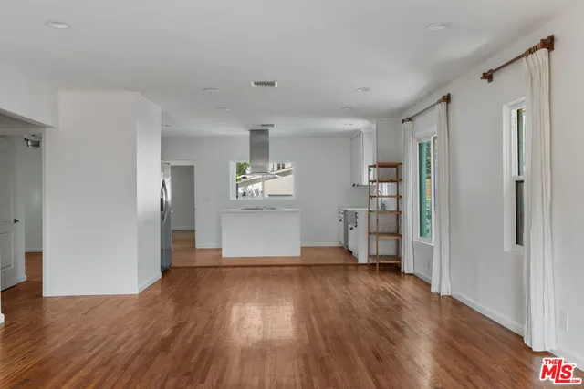 a large white kitchen with stainless steel appliances