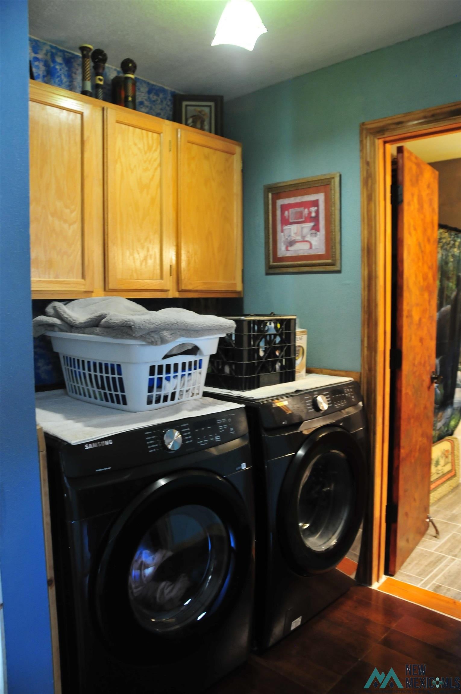 25 Bluff Road Thoreau, NM 87323 - Photo 22 of 31 Dedicated laundry area featuring wood-finish flooring, light wood cabinetry, and a dark stone-look countertop