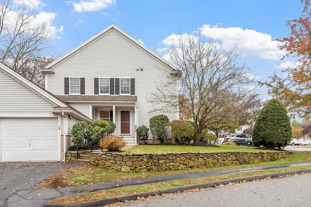 a view of a white house with a yard and potted plants