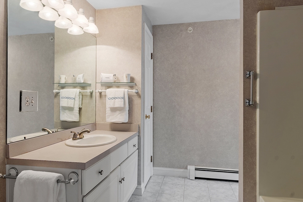 28 Partridge Lane, Unit 28 Lynnfield, MA 01940 - Photo 31 of 41 a bathroom with a sink a mirror and a shower