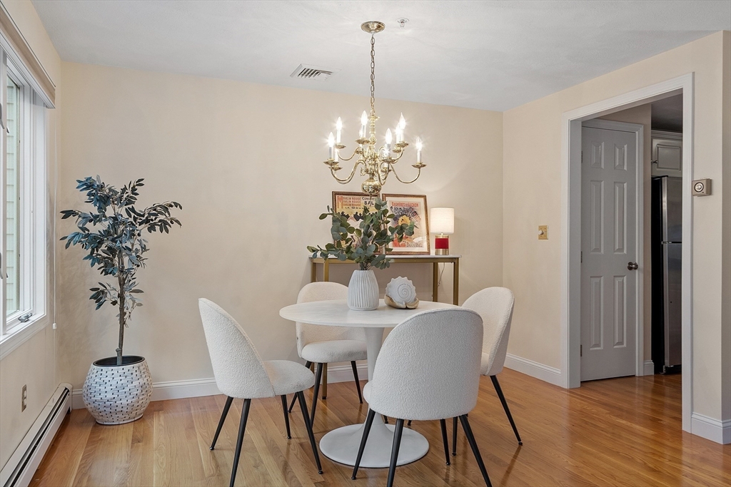 28 Partridge Lane, Unit 28 Lynnfield, MA 01940 - Photo 8 of 41 a dining room with furniture potted plants and wooden floor