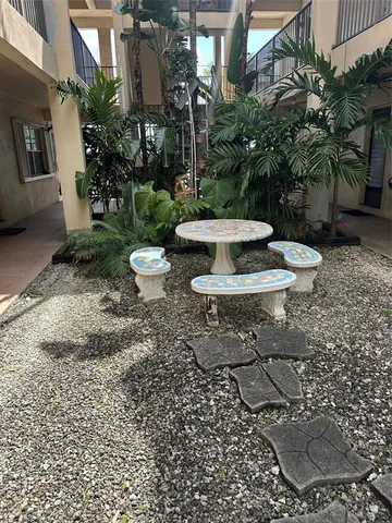 a view of a backyard with plants and a patio