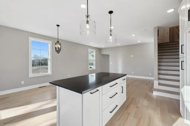 a kitchen with stainless steel appliances granite countertop a sink a oven and a chandelier