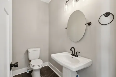 a bathroom with a sink a toilet and a mirror