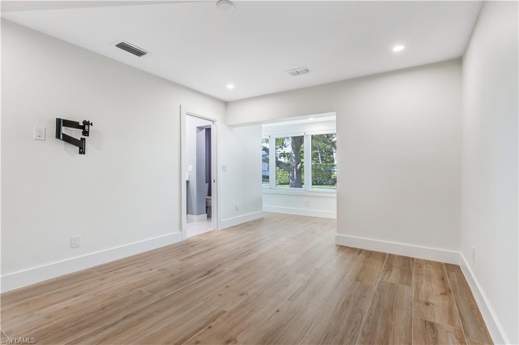 1019 7th Street South Naples, FL 34102 - Photo 11 of 30 wooden floor in an empty room with a window