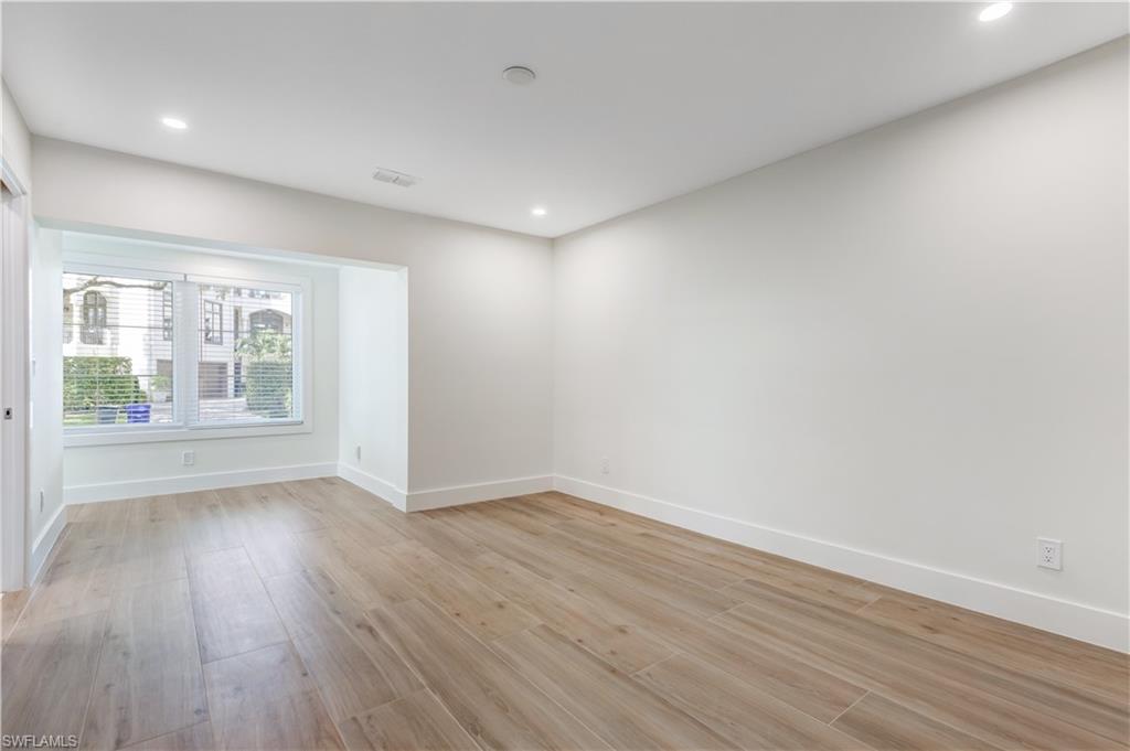 1019 7th Street South Naples, FL 34102 - Photo 13 of 30 wooden floor in an empty room with a window