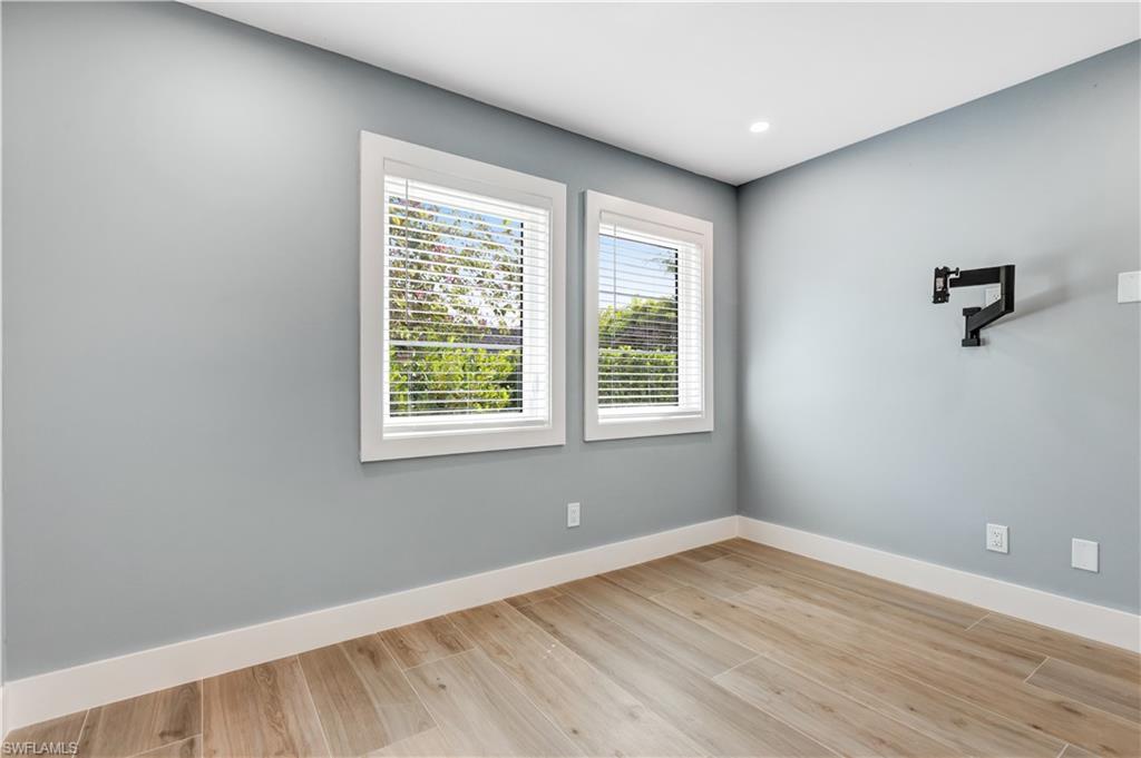 1019 7th Street South Naples, FL 34102 - Photo 18 of 30 an empty room with wooden floor and windows