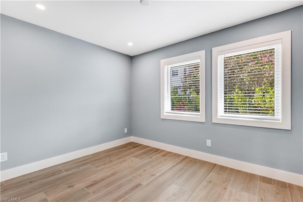 1019 7th Street South Naples, FL 34102 - Photo 19 of 30 an empty room with wooden floor and windows