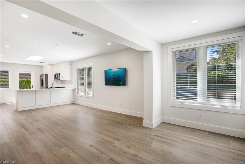 1019 7th Street South Naples, FL 34102 - Photo 3 of 30 a view of an empty room with wooden floor and a window