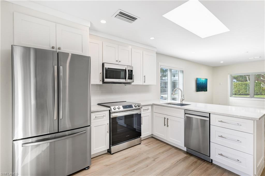 1019 7th Street South Naples, FL 34102 - Photo 6 of 30 a kitchen with stainless steel appliances a refrigerator sink and microwave