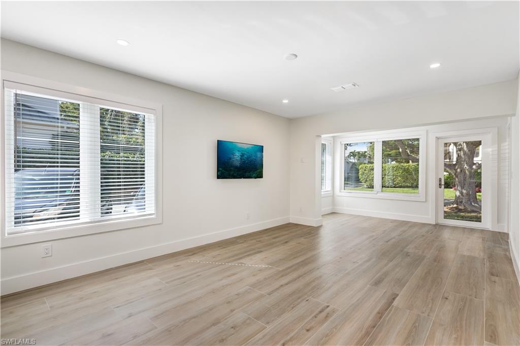1019 7th Street South Naples, FL 34102 - Photo 9 of 30 a view of an empty room with wooden floor and a window