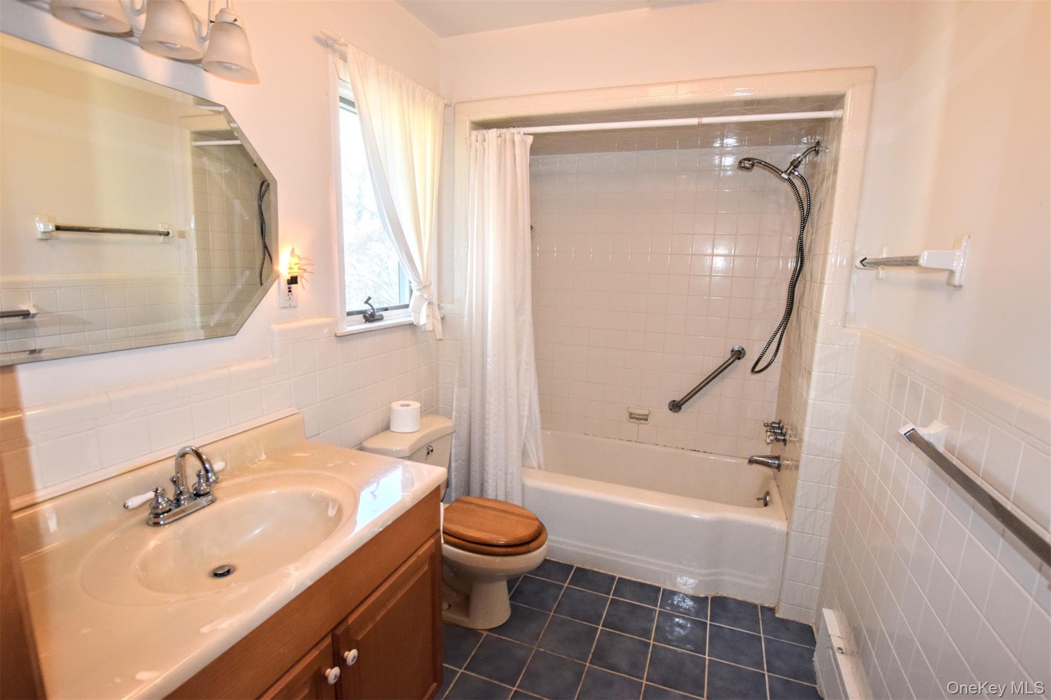 41 Country Club Road Bellport, NY 11713 - Photo 16 of 18 Full bathroom with tile walls, a wainscoted wall, vanity, shower / bath combo with shower curtain, and dark tile patterned flooring