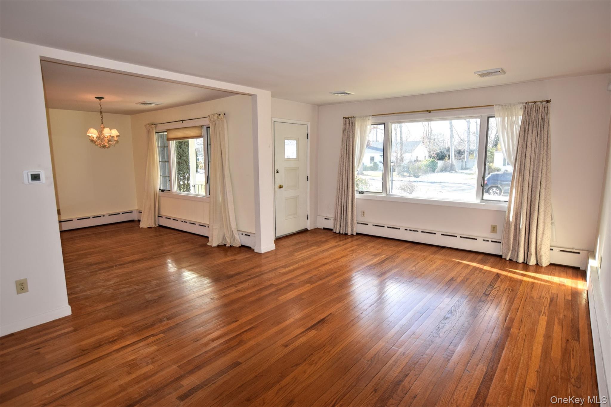41 Country Club Road Bellport, NY 11713 - Photo 10 of 18 Foyer with a chandelier, hardwood / wood-style floors, and a baseboard radiator